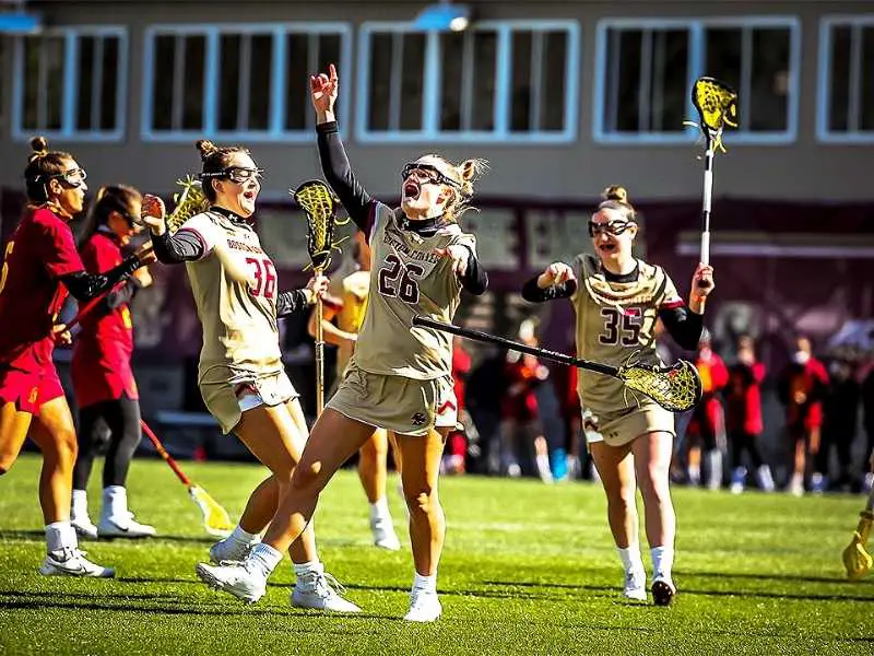 women's lacrosse players throw their sticks