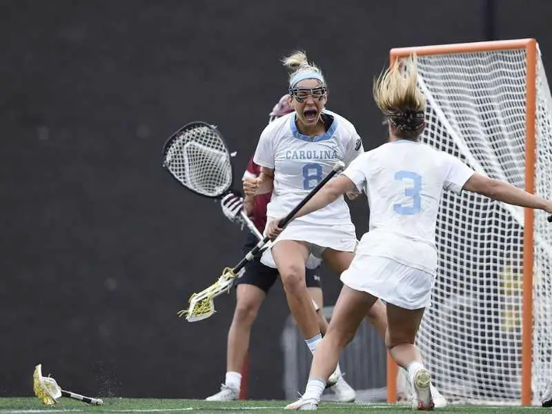 women's lacrosse players throw their sticks